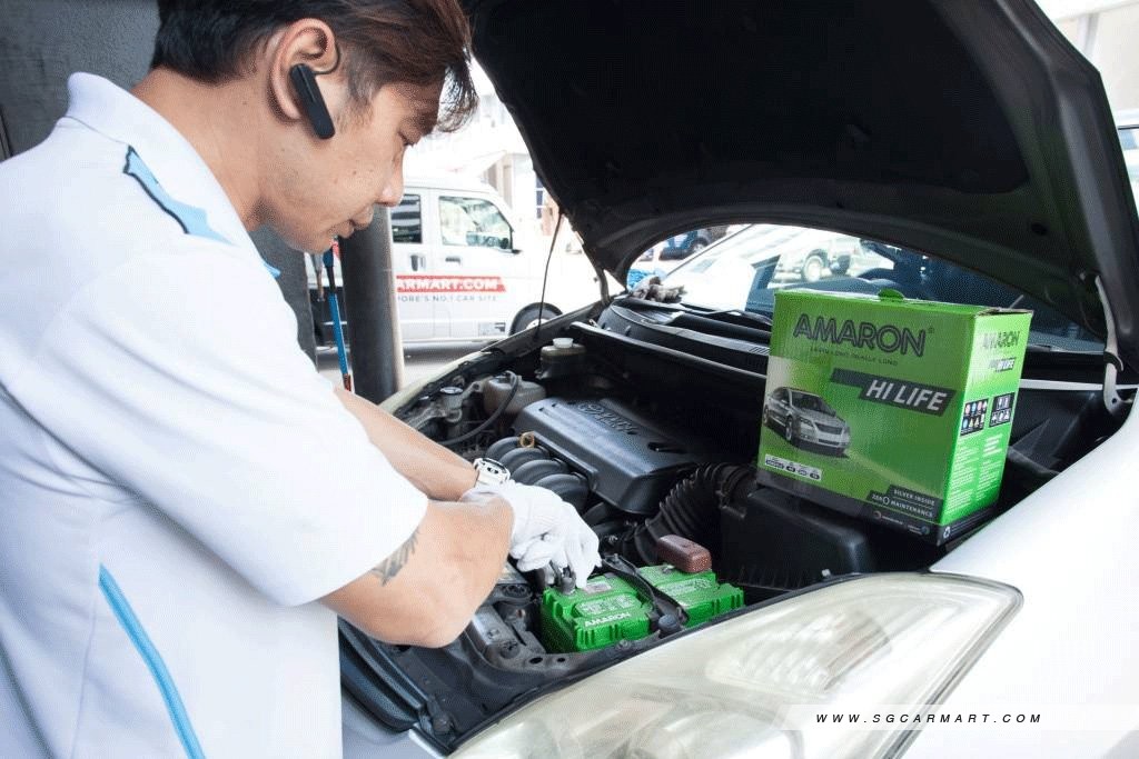 asian man working on car battery